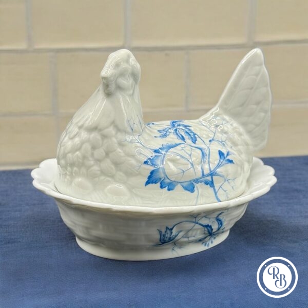 Bonbonnière ovale (ou sucrier) en porcelaine blanche de Limoges - Estampillée Giraud - Représentant une poule sur son nid d'osier tressé - Décor floral bleu - Décoration - Collection